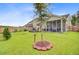 A large backyard with a patio, screened in porch, and a tree in the center of the yard at 135 Cypress Preserve Blvd, Moncks Corner, SC 29461