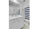 Bright bathroom with white cabinets, framed mirror, and a shower with a striped curtain at 135 Cypress Preserve Blvd, Moncks Corner, SC 29461