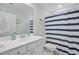 Well-lit bathroom with white cabinets, framed mirror, and a shower with striped curtain at 135 Cypress Preserve Blvd, Moncks Corner, SC 29461