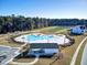 A clear aerial view of the community pool area, featuring a uniquely designed pool, a pool house, and ample parking at 135 Cypress Preserve Blvd, Moncks Corner, SC 29461