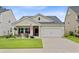 Charming single-story home with a well-manicured lawn, attached two-car garage, and quaint porch at 135 Cypress Preserve Blvd, Moncks Corner, SC 29461