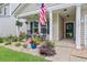Cozy front porch with rocking chairs, hanging flower baskets, and a beautifully landscaped garden at 135 Cypress Preserve Blvd, Moncks Corner, SC 29461