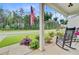 Inviting front porch featuring rocking chairs, hanging plants, and lush landscaping at 135 Cypress Preserve Blvd, Moncks Corner, SC 29461