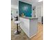 An eat-in kitchen with modern white cabinets, bar stool and decorative blue accent wall at 1351 Winifred St, Mount Pleasant, SC 29464