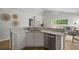 Open kitchen with white cabinets, quartz countertops, stainless steel dishwasher, and views into the living room at 1420 Wellesley Cir, Mount Pleasant, SC 29466