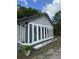 Exterior view of a sunroom with a white door and a row of windows, surrounded by lush plants at 1488 Remount Rd, North Charleston, SC 29406