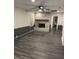 Bright living room with a brick fireplace, ceiling fan, dark vinyl floors and contemporary wall trim at 1488 Remount Rd, North Charleston, SC 29406