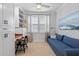 Bright home office with built-in shelving, wood desk, and comfortable blue sofa at 1535 Low Pk St, Mount Pleasant, SC 29464