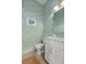 Stylish powder room featuring a decorative green wallpaper, a modern vanity, and light wood floors at 1535 Low Pk St, Mount Pleasant, SC 29464