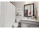 Bathroom featuring a vanity with a gray cabinet, large mirror, toilet and shower with decorative white curtain at 154 Calm Water Way, Summerville, SC 29486