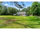Charming exterior of a country-style home with a large, manicured lawn and mature trees at 162 Whippoorwill Dr, Summerville, SC 29483