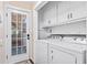 A fully-equipped laundry room with a washer, dryer, and built-in storage cabinets at 162 Whippoorwill Dr, Summerville, SC 29483