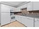 This kitchen features white appliances, cabinetry, stainless steel sink and a light speckled countertop at 1713 Boone Hall Dr # 1082, Charleston, SC 29407