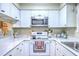 Well-lit kitchen features white cabinets, granite counters, and stainless steel appliances at 18 Indigo Ln, Goose Creek, SC 29445