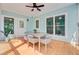 Back porch featuring a dining table, ceiling fan, and serene wooded views from the windows at 18 Tupelo Trl, Edisto Island, SC 29438