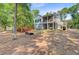 Wooded backyard featuring mature trees, a fire pit, a shed, and a deck at 18 Tupelo Trl, Edisto Island, SC 29438
