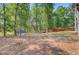 Wooded backyard featuring mature trees, a fire pit, a shed, and a deck at 18 Tupelo Trl, Edisto Island, SC 29438