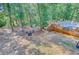 Backyard view with a wood deck, pool, fire pit area, and mature trees at 18 Tupelo Trl, Edisto Island, SC 29438