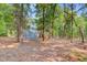 A spacious backyard view with mature trees, lush foliage, and the house with covered deck at 18 Tupelo Trl, Edisto Island, SC 29438
