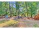 Wooded backyard featuring mature trees, a fire pit, a shed, and a deck at 18 Tupelo Trl, Edisto Island, SC 29438
