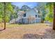 Exterior view of elevated home showing the crawlspace, double stairs and surrounding landscaping at 18 Tupelo Trl, Edisto Island, SC 29438