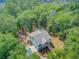 Exterior view of elevated home with metal roof, double staircases, and surrounded by lush trees at 18 Tupelo Trl, Edisto Island, SC 29438