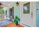 Inviting front porch with a bench, door, and vibrant green plants at 18 Tupelo Trl, Edisto Island, SC 29438