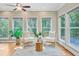 Bright sunroom featuring large windows, stylish seating, ceiling fan, and hardwood floors at 18 Tupelo Trl, Edisto Island, SC 29438