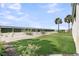 Landscaped backyard with artificial turf, palm trees, and a secure fence for privacy at 210 Ocean Blvd, Isle of Palms, SC 29451