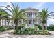 Charming two-story home with a welcoming porch, set amongst lush tropical landscaping and a brick driveway at 210 Ocean Blvd, Isle of Palms, SC 29451