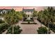 Stunning home with palm-lined drive and meticulously landscaped grounds highlighted against a beautiful sunset backdrop at 210 Ocean Blvd, Isle of Palms, SC 29451