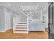 Bright foyer with a white staircase, hardwood floors, and decorative furniture at 210 Ocean Blvd, Isle of Palms, SC 29451