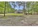 Large backyard with mature trees offering privacy and a brick home with screened porch at 213 Turtle Point Rd, Summerville, SC 29483