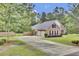 Exterior shot showcasing a long driveway leading to a two-car garage and gated entrance at 213 Turtle Point Rd, Summerville, SC 29483