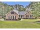 Charming brick home with a well-manicured lawn, mature trees, and a welcoming front porch at 213 Turtle Point Rd, Summerville, SC 29483