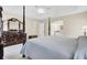 Bright main bedroom featuring tray ceiling, four-poster bed, wood floors, and ensuite bathroom at 213 Turtle Point Rd, Summerville, SC 29483