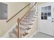 Carpeted staircase leading to the upper level, featuring wood railings and a nearby entrance door at 213 Turtle Point Rd, Summerville, SC 29483