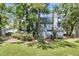 Home's rear exterior with lush greenery, mature trees, and well-maintained lawn at 2159 Spoleto Ln # E, North Charleston, SC 29406