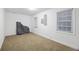 A spare bedroom with neutral carpet, white walls, windows, and a package in the corner at 2206 Weepoolow Trl, Charleston, SC 29407