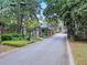 Gated community entrance with brick pillars, manicured landscaping, and charming entry structure at 2206 Weepoolow Trl, Charleston, SC 29407