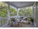 Covered porch with comfortable seating, a table and view of lush greenery at 2206 Weepoolow Trl, Charleston, SC 29407