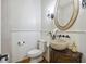 Stylish powder room with a unique vessel sink, decorative mirror, and elegant sconces at 2206 Weepoolow Trl, Charleston, SC 29407