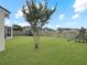 Spacious backyard with a lush lawn, mature tree, playset, and a fence for added privacy at 224 Market Hall St, Moncks Corner, SC 29461