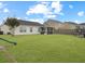 Wide-open backyard with lush grass, play set, trampoline and screened porch for outdoor activities and relaxation at 224 Market Hall St, Moncks Corner, SC 29461