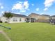 Expansive backyard with lush green grass, a playset, trampoline and a screened patio perfect for entertaining at 224 Market Hall St, Moncks Corner, SC 29461