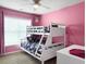 Vibrant bedroom with pink walls, a white bunk bed with patterned bedding, and a ceiling fan at 224 Market Hall St, Moncks Corner, SC 29461