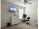 Functional bedroom with a wall-mounted TV, white dresser, desk setup, ceiling fan, and neutral carpet at 224 Market Hall St, Moncks Corner, SC 29461