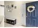 Inviting entryway features a decorative wreath on a dark blue door, a bench with shoe storage, and stylish wall decor at 224 Market Hall St, Moncks Corner, SC 29461
