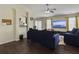 Open-concept living room with hardwood floors features blue sofas and views to the backyard and kitchen at 224 Market Hall St, Moncks Corner, SC 29461