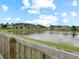 Scenic pond view from the backyard featuring a wooden fence, lush greenery, and picturesque neighborhood homes at 224 Market Hall St, Moncks Corner, SC 29461
